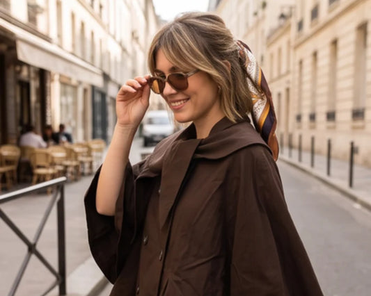 Trench kaki porté ouvert sur une robe fluide imprimée