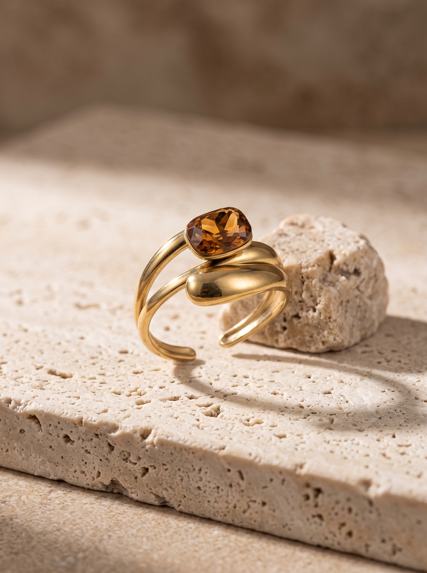 Détail du cristal ambre serti clos et de l'anneau double ouvert