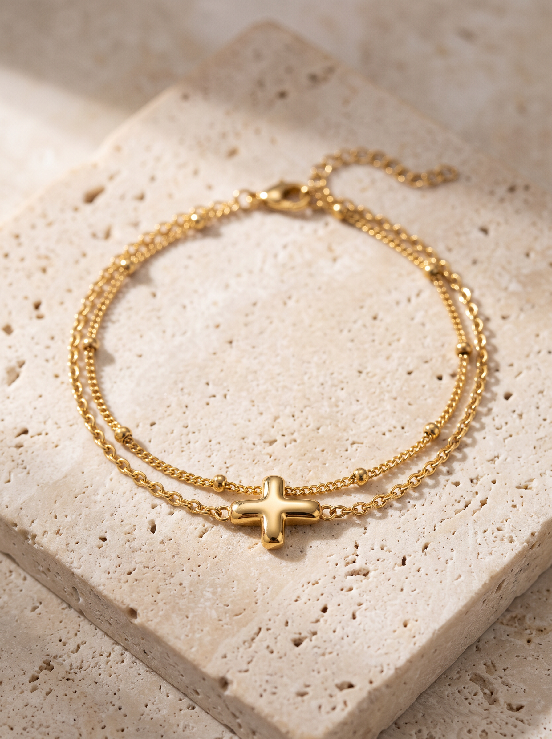 Bracelet doré à pendentif croix, packshot fond clair