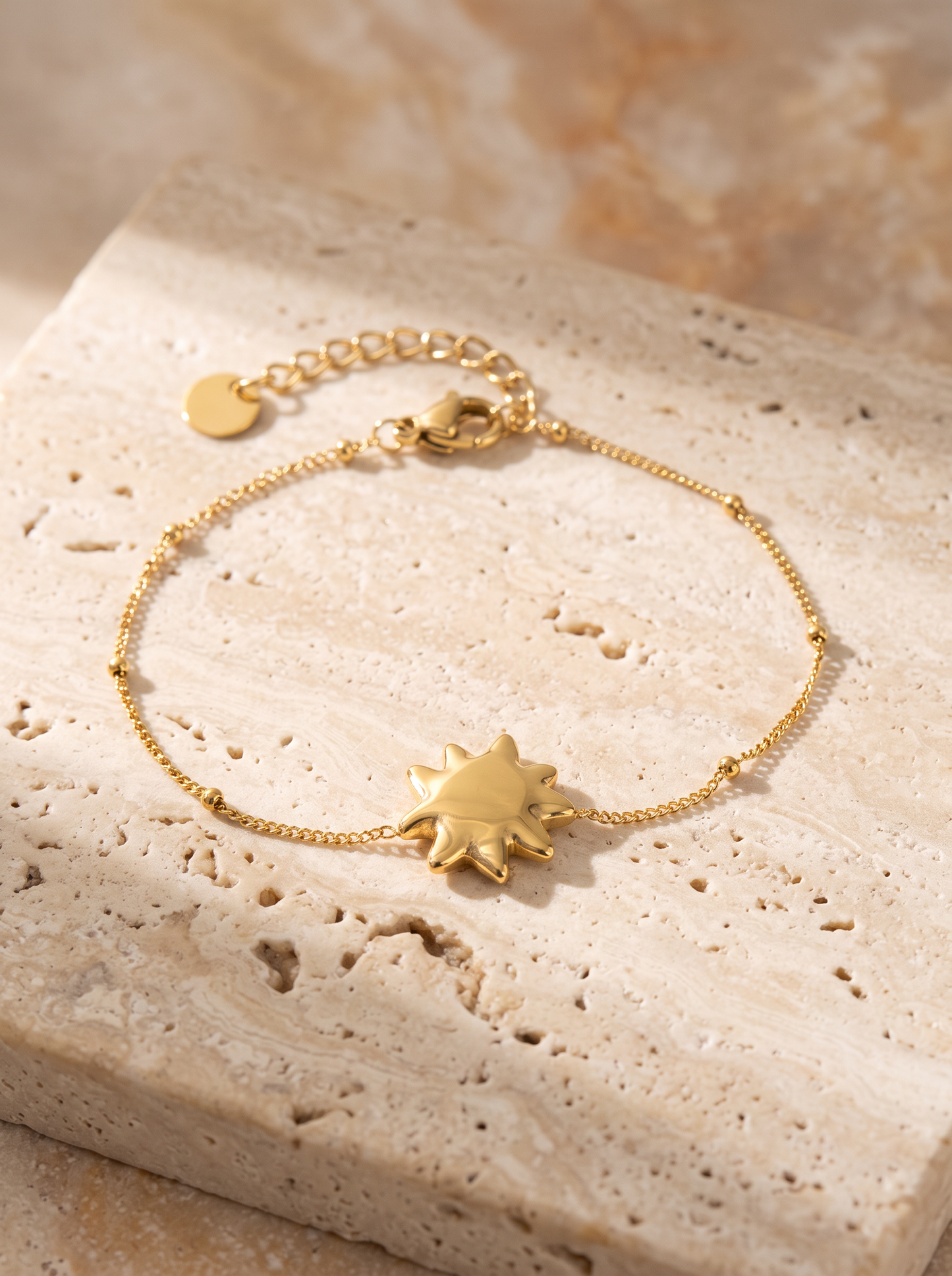 Bracelet doré à pendentif soleil, packshot fond clair