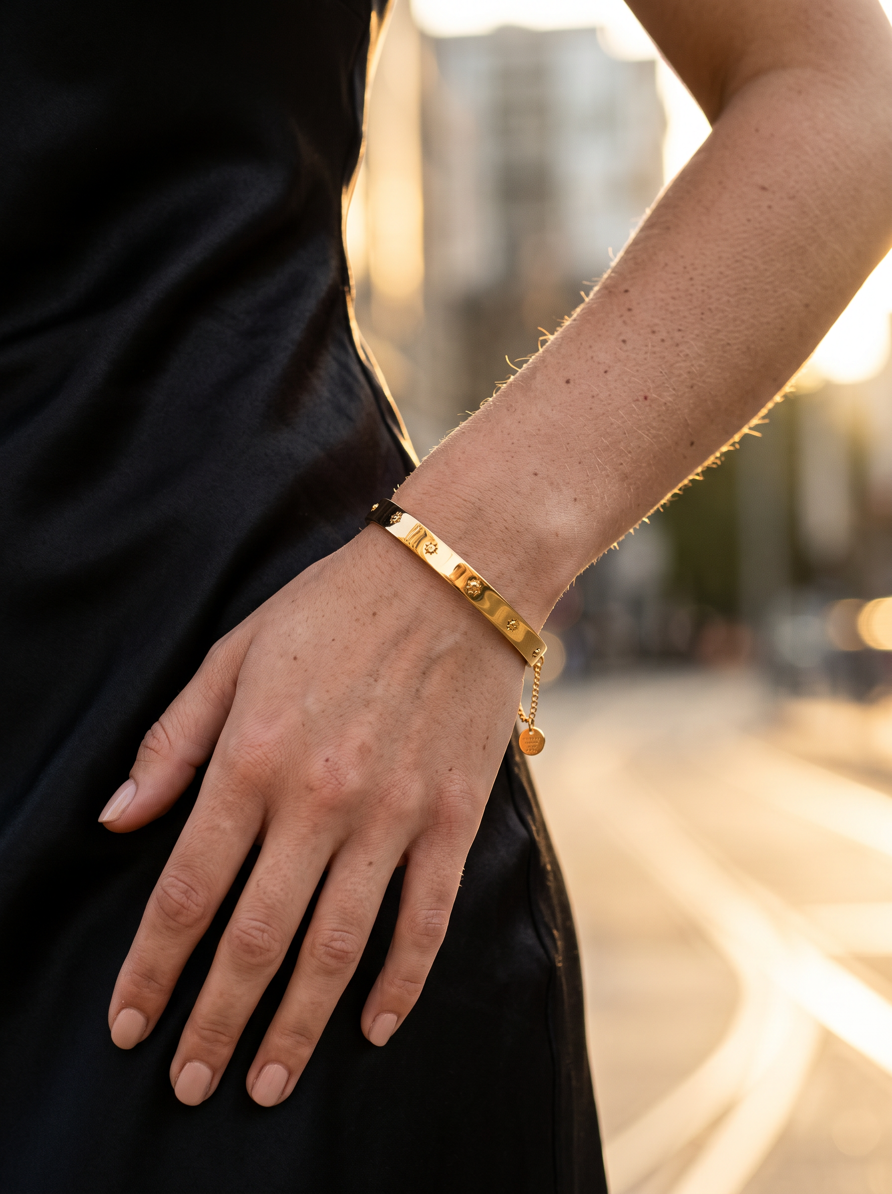 Bracelet jonc doré porté au poignet, ligne épurée