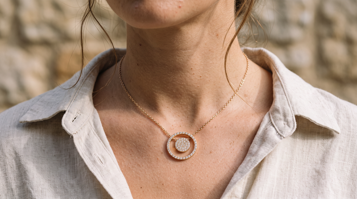 Détail du pendentif rond doré sur chaîne fine